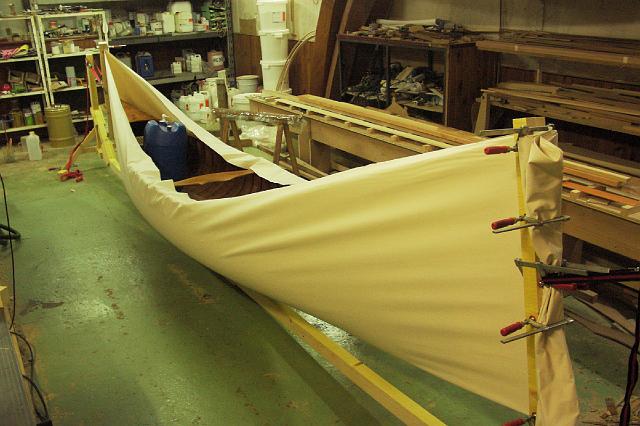 PICT1967.JPG - Entoilage: La toile (coton 300 à 500 g/m²) est pliée en deux puis tendue entre deux mors, le bateau est placé au milieu et chargé de poids. Sous l'effet des tensions dans les deux directions, la toile se déforme et épouse la coque.